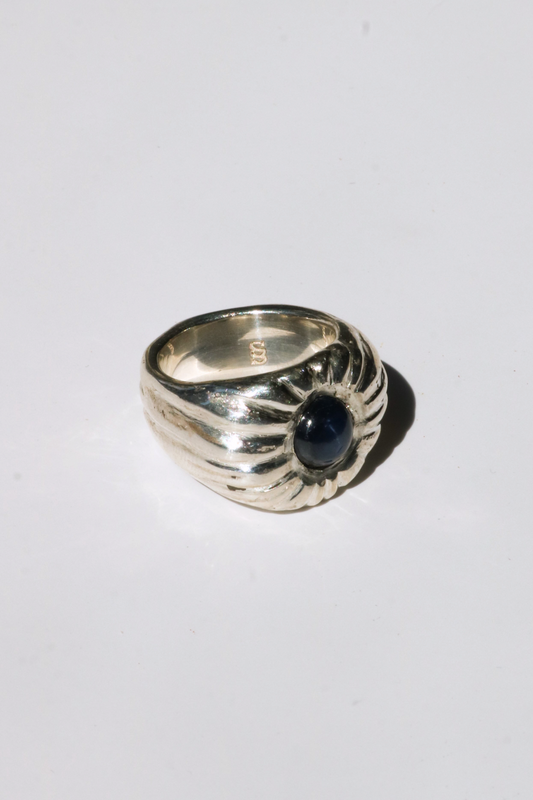 Odissea Dean ring featuring a chunky sculptural silver band with a central blue star sapphire gemstone