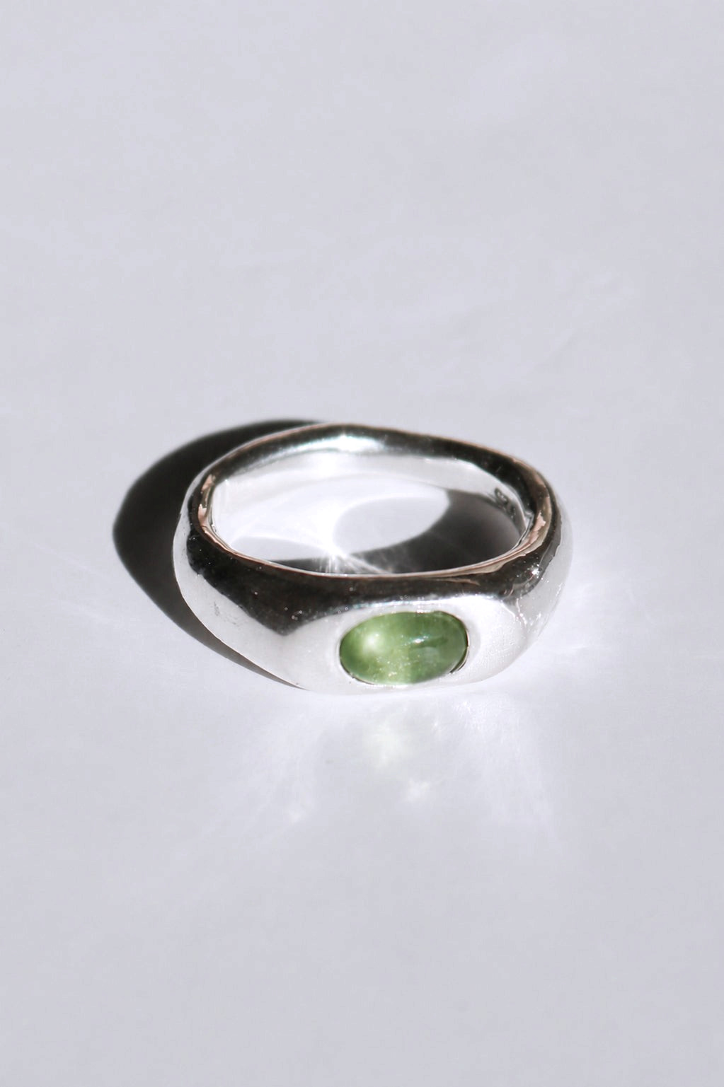 Odissea Aurelia ring in polished sterling silver with a smooth, curved band and a green cabochon tourmaline stone.