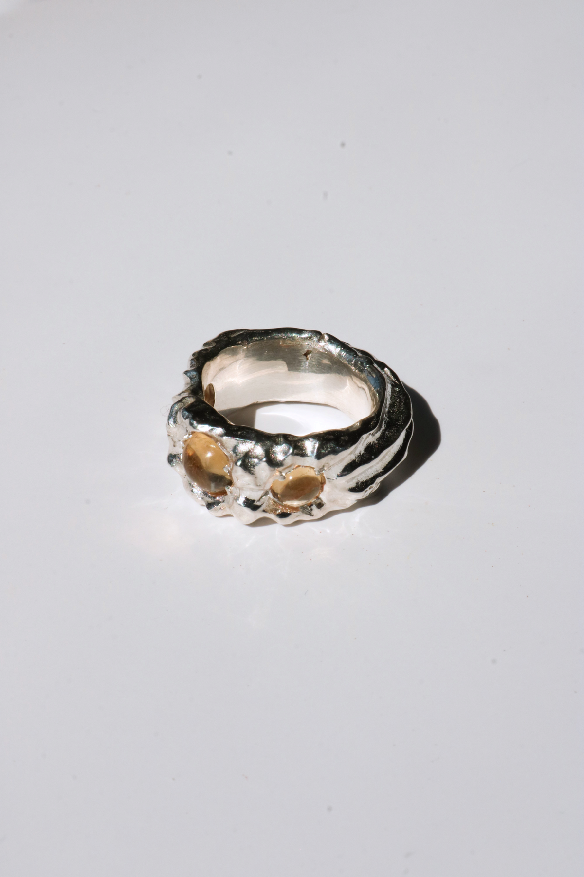 Odissea Isidore ring featuring a chunky, sculptural silver band set with two round citrine gemstones.