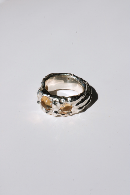 Odissea Isidore ring featuring a chunky, sculptural silver band set with two round citrine gemstones.