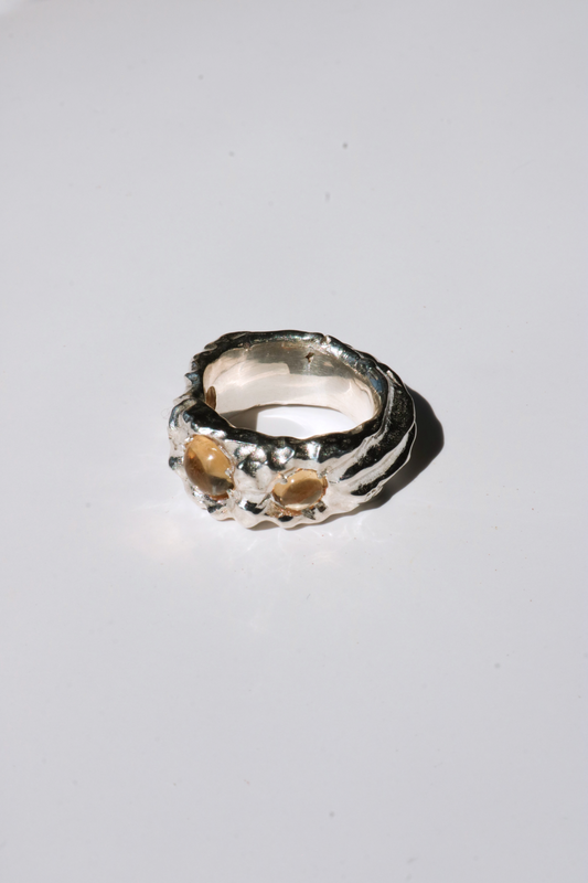 Odissea Isidore ring featuring a chunky, sculptural silver band set with two round citrine gemstones.
