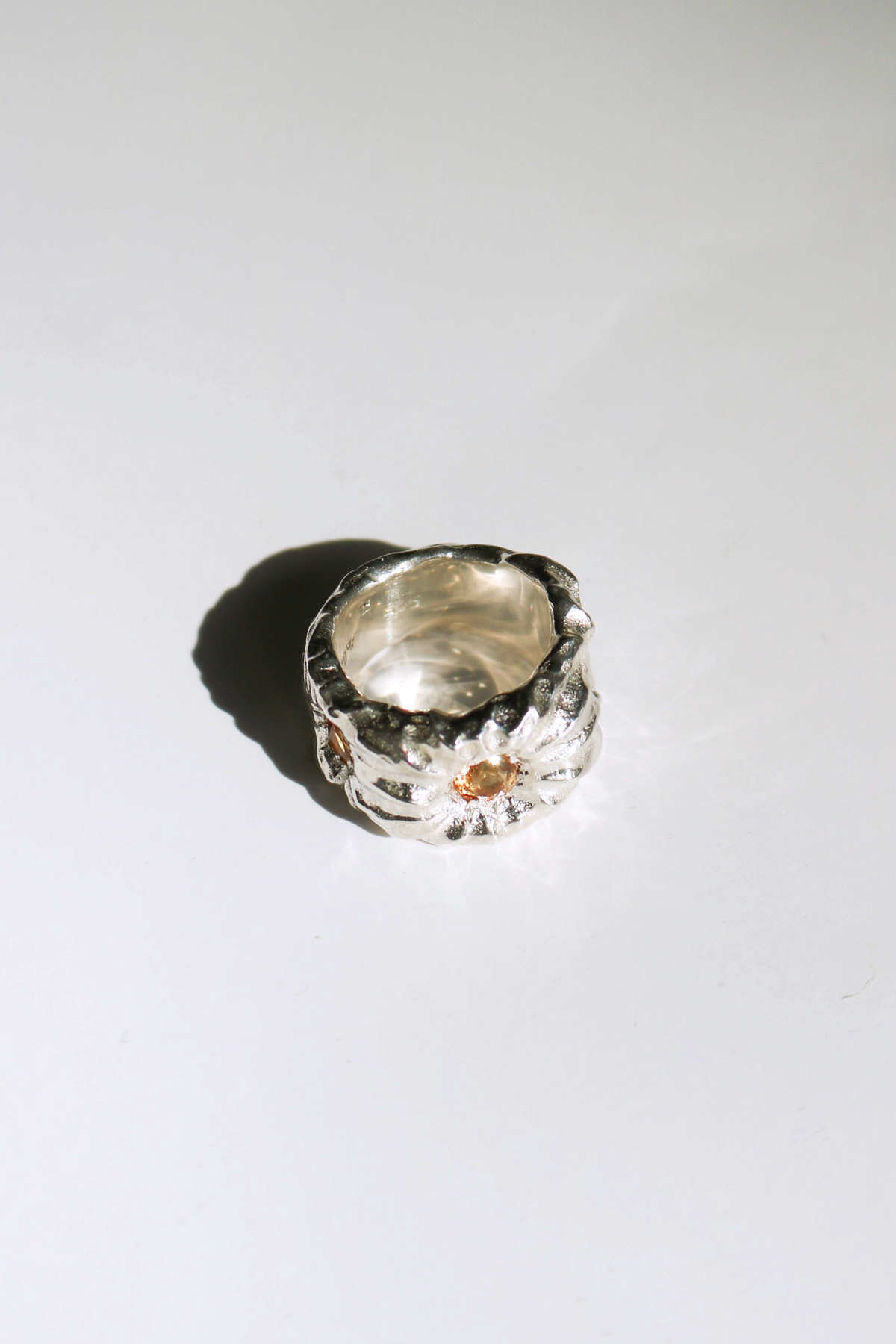 Odissea Willow Ring featuring a chunky, sculptural silver band with a small, warm citrine gemstone inlay.